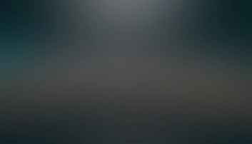 Blurry, abstract image with a gradient of dark colors, fading from darker tones at the edges to lighter ones in the center.